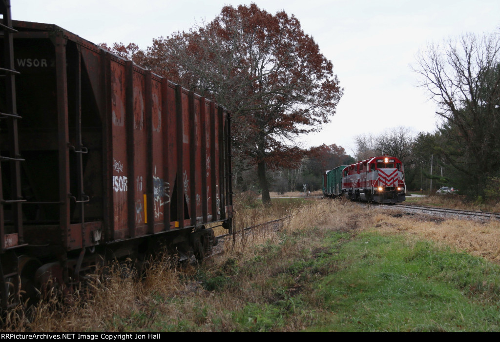 Ballast hoppers sit in storage on one of the legs of the wye as L593 passes